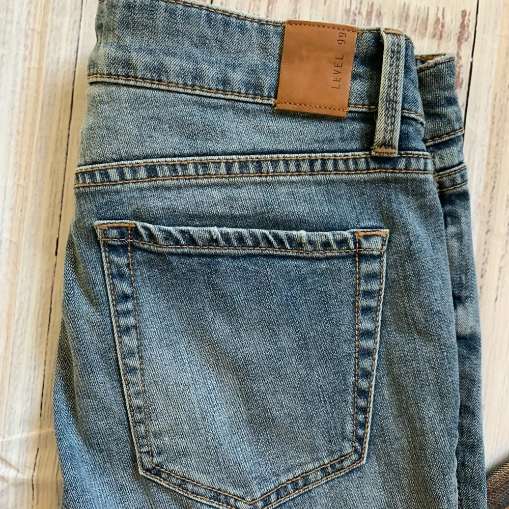 Level 99 jeans. Gold/silver design on bottom. Mid rise. Size 27.